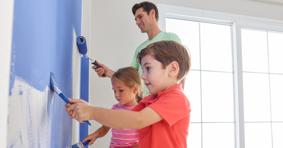 Kinds and their father painting the walls of their mobile home